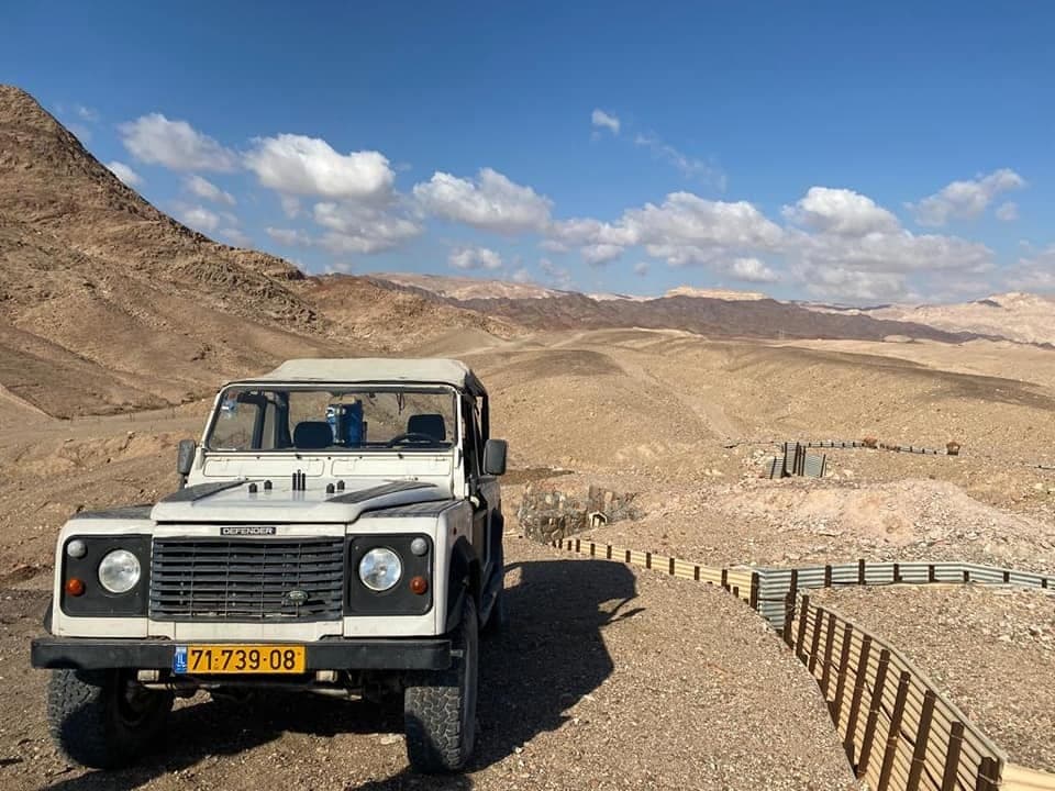 ג׳יפ דיפנדר בנקודת תצפית מול רכסי ההרים
